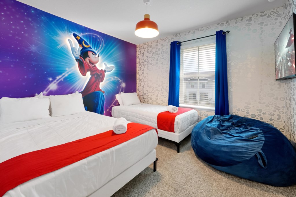 Bedroom 2: Whimsical bedroom with Mickey themed mural, twin beds, and cozy bean bag chair.