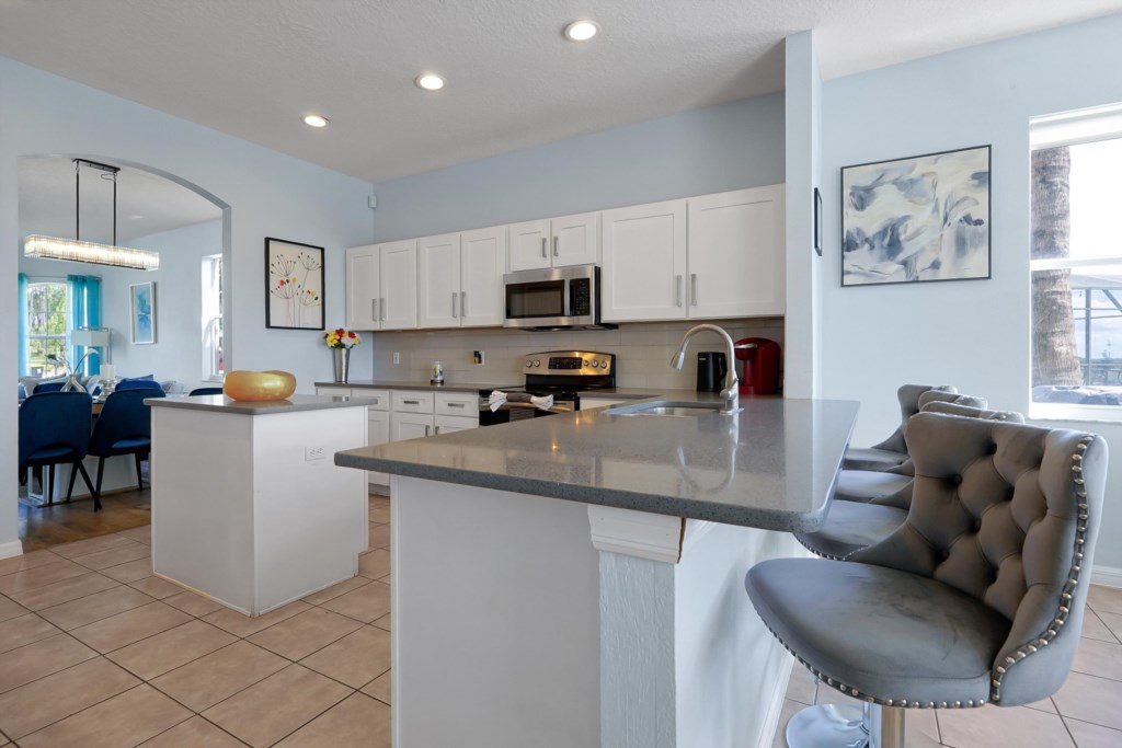 4 stylish breakfast bar stools offer a perfect vantage point, allowing you to overlook the vibrant and well-equipped kit