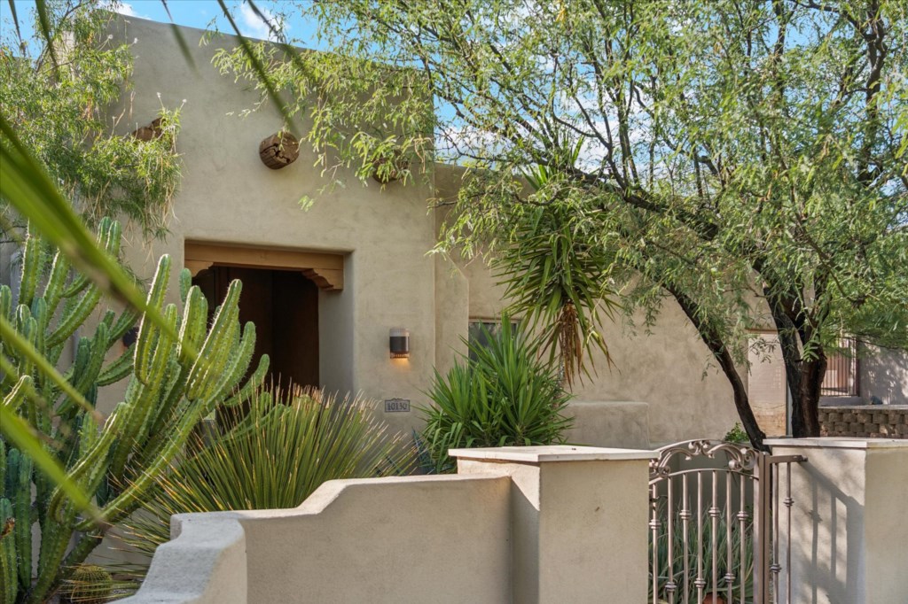 Serene entrance to a Southwestern-style home, surrounded by native plants.