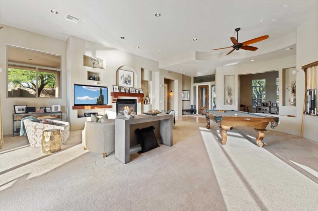 Spacious living area with fireplace, pool table, and cozy seating.