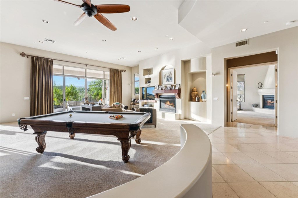 Luxurious game room with pool table, modern furnishings, and sweeping views.
