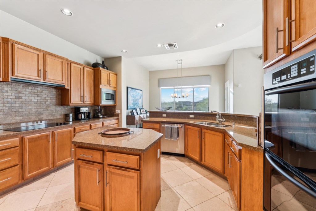 Modern kitchen with spacious granite countertops and stainless steel appliances.