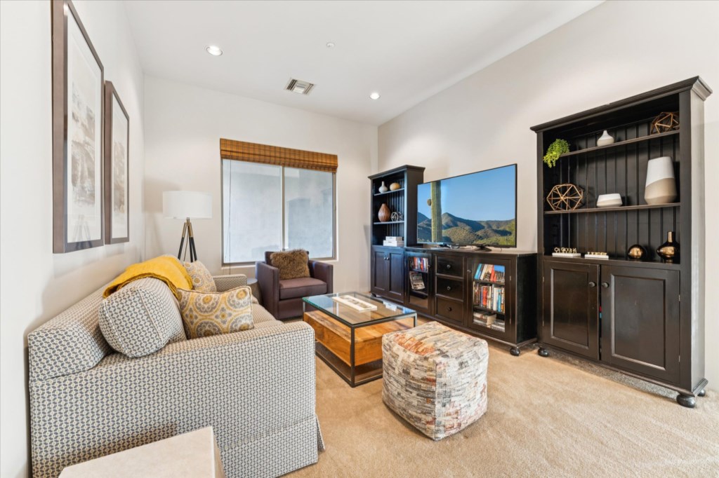 Bright living room with a cozy seating area and expansive bookshelf unit.