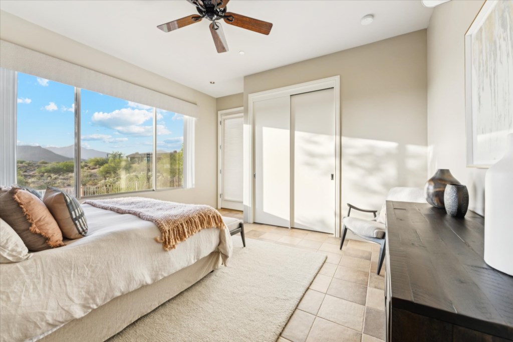 Serene bedroom with sweeping views of the desert landscape.