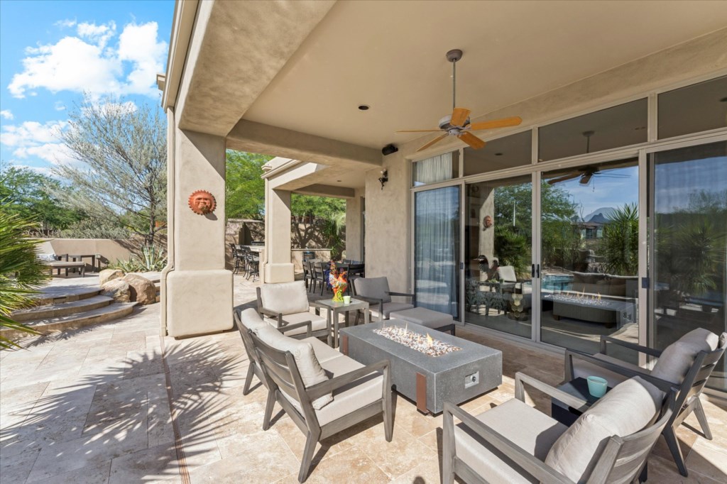 Spacious patio with comfortable seating and a modern fire pit, ideal for relaxation.