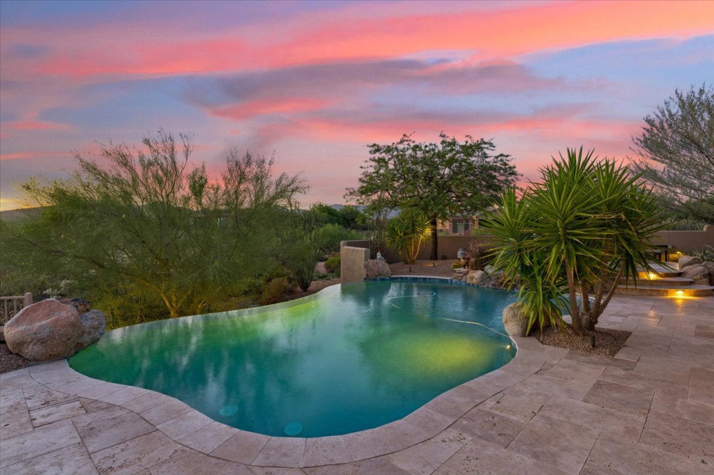 Serene poolside tranquility beneath a vivid sunset, ideal for evening relaxation.
