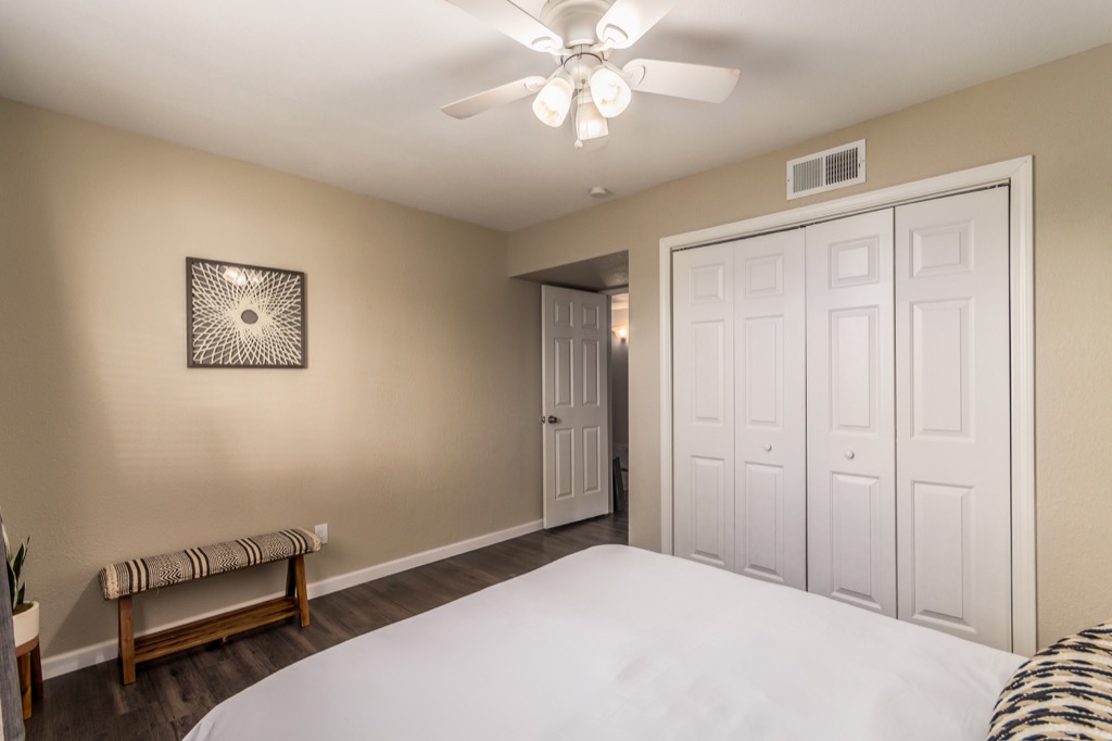 Sleek and spacious bedroom with large closet and modern ceiling fan.