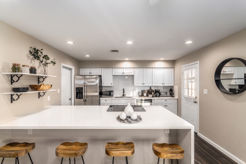 Modern kitchen with bar seating and stainless steel appliances.