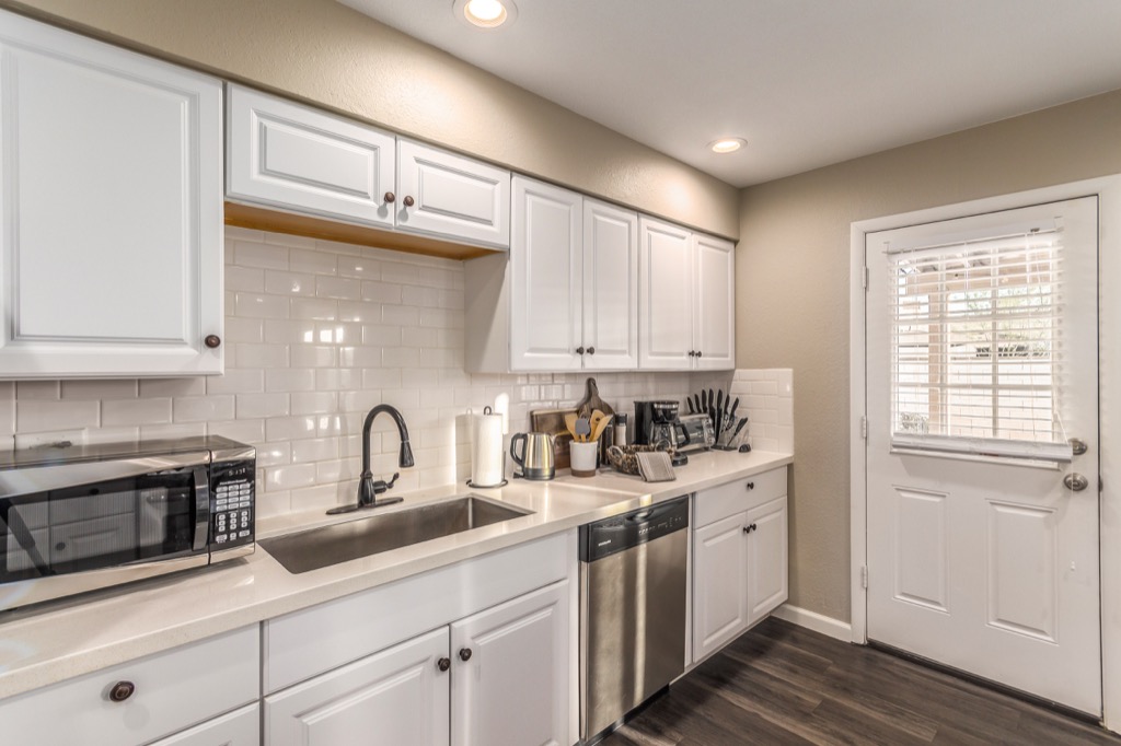 Modern kitchen with stainless steel appliances and sleek white cabinetry.