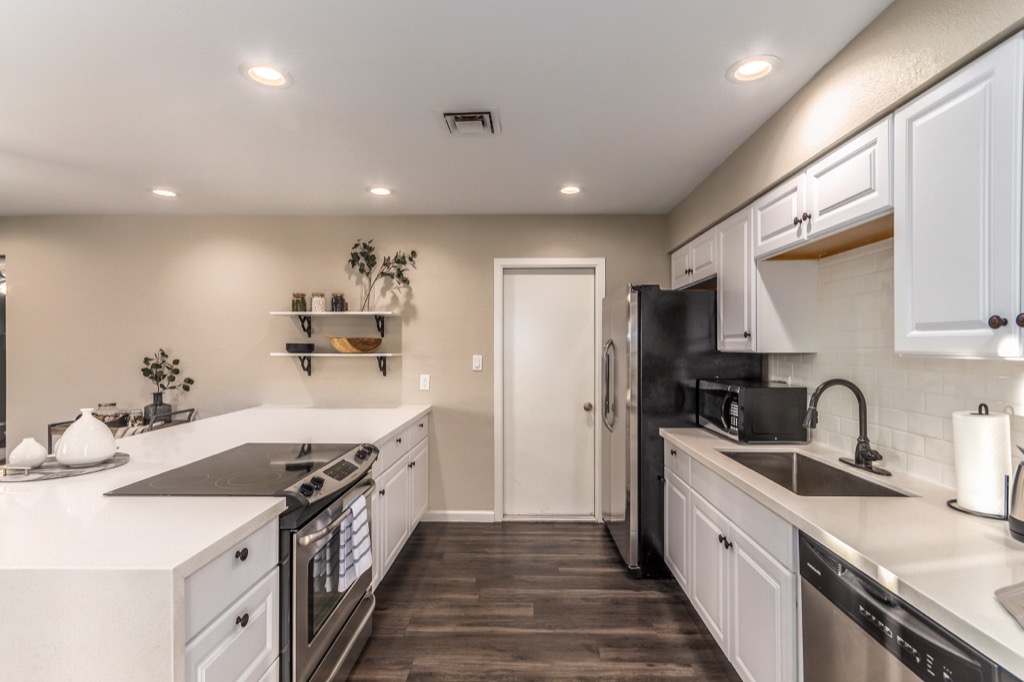 Modern kitchen with white cabinetry and sleek appliances, ideal for meal prep.