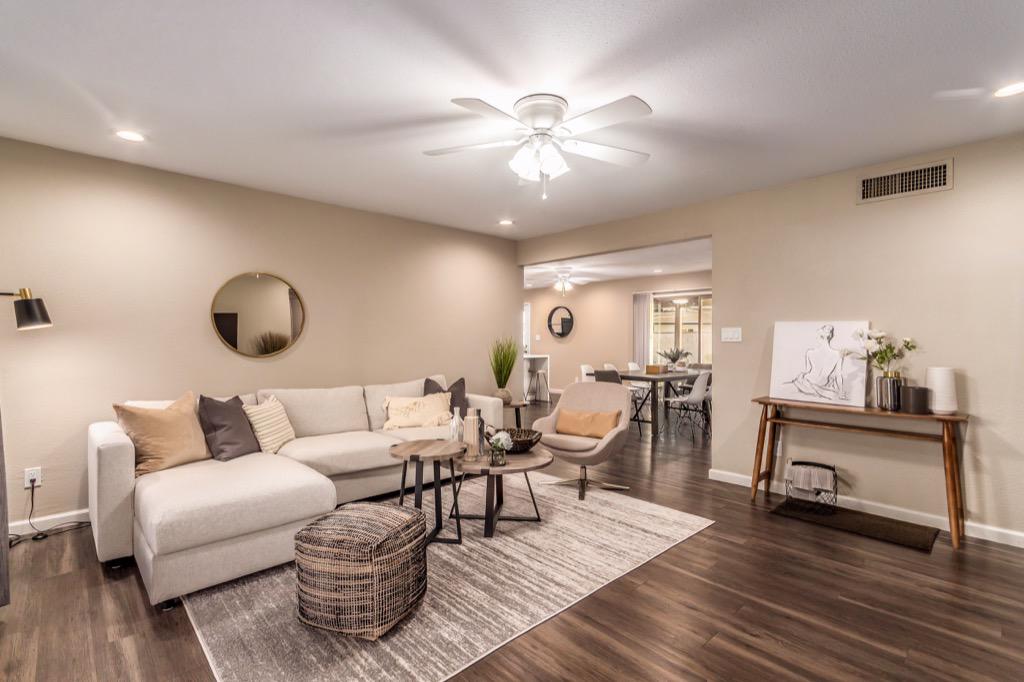 Spacious living room with comfortable seating and modern decor, leading to a well-lit dining area.