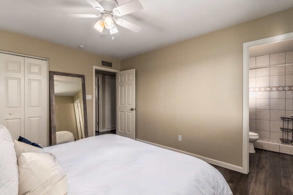 Spacious bedroom with ensuite bathroom and modern ceiling fan.