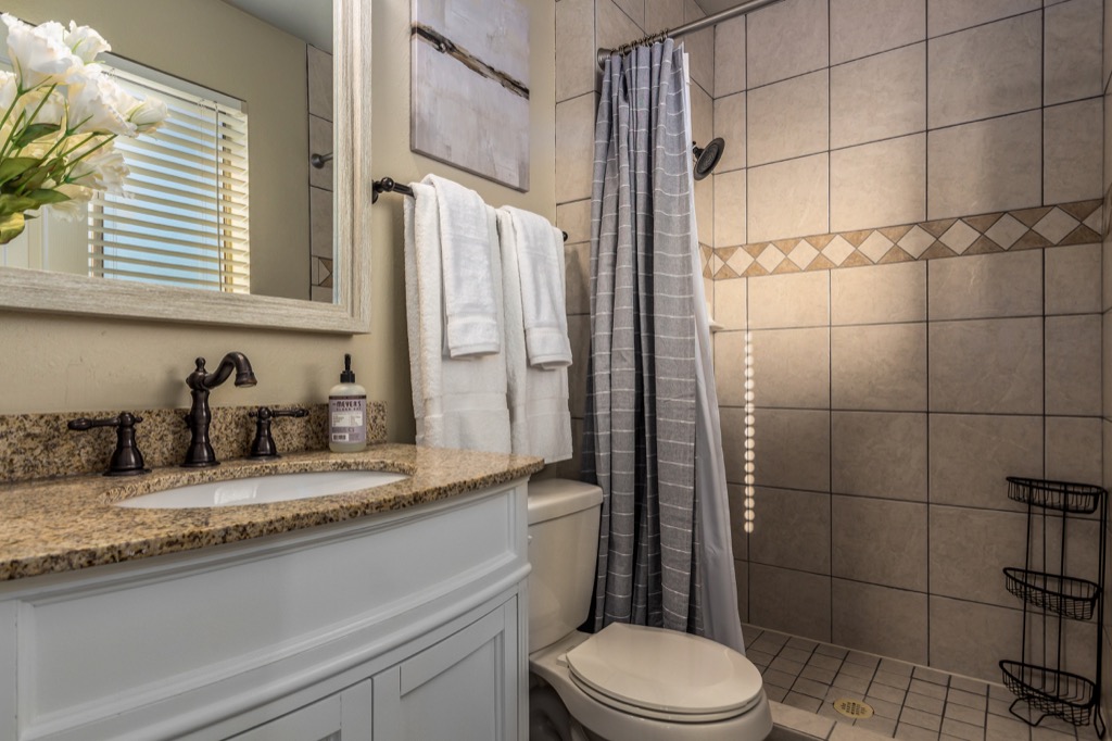 Bright bathroom with elegant stone tiles and modern amenities.