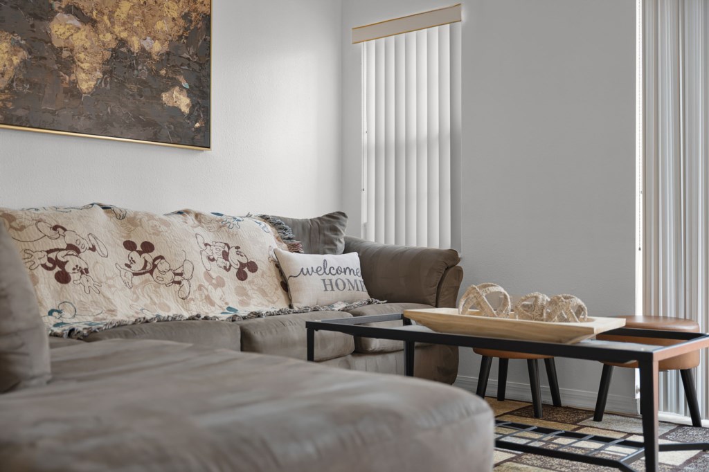 Spacious open-concept living room with plush seating and large windows.