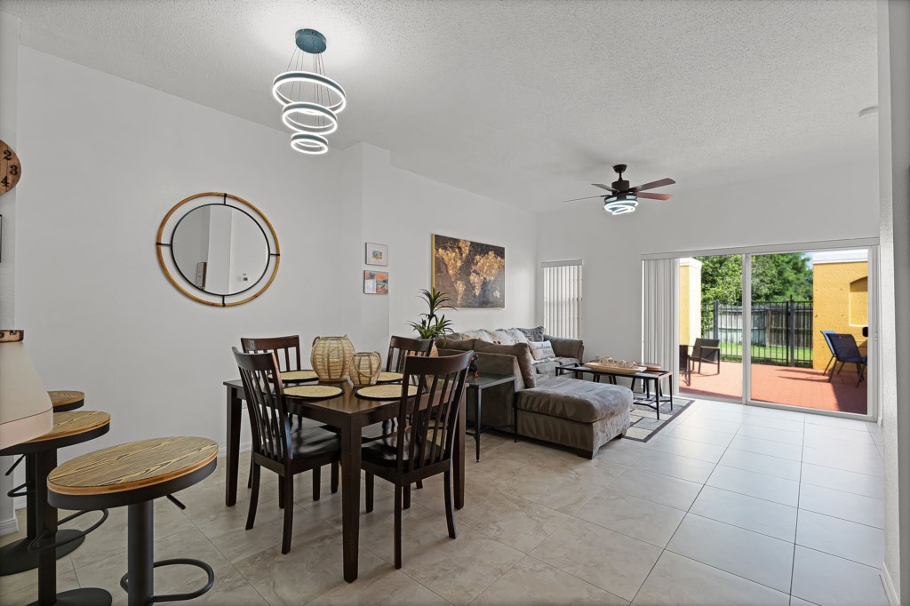 Bright living area with dining set, cozy couch, and direct access to the patio.