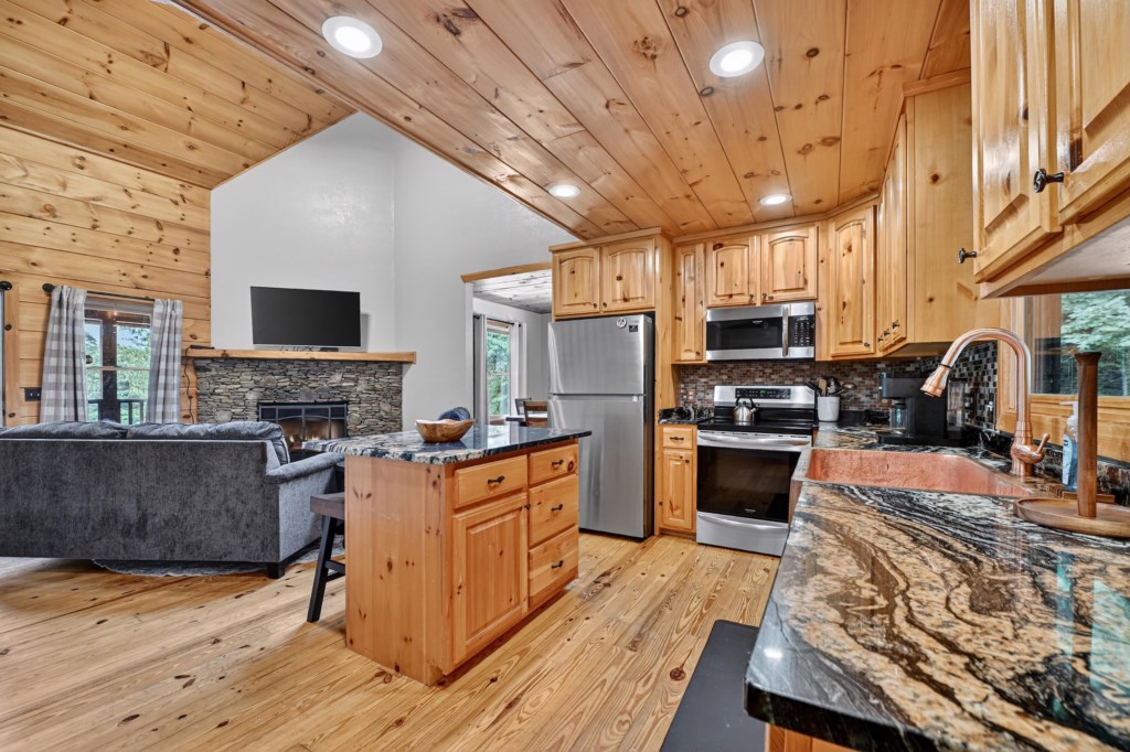 Open layout featuring a cozy living area and a fully-equipped kitchen with modern appliances.