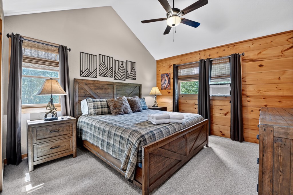 Rustic cabin-style bedroom with a cozy plaid comforter and wooden decor.