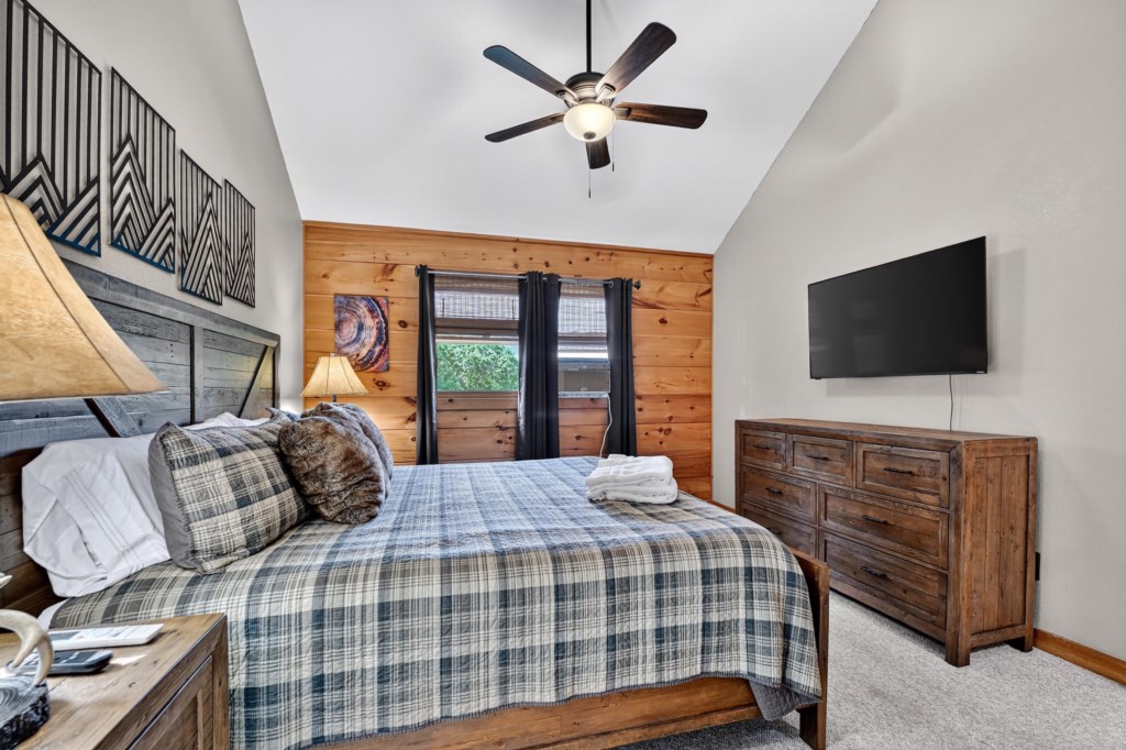 Rustic bedroom with wood-paneled walls and direct patio access.