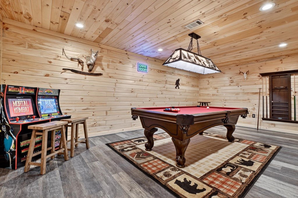 Rustic-style game room with pool table and arcade games, perfect for family fun.