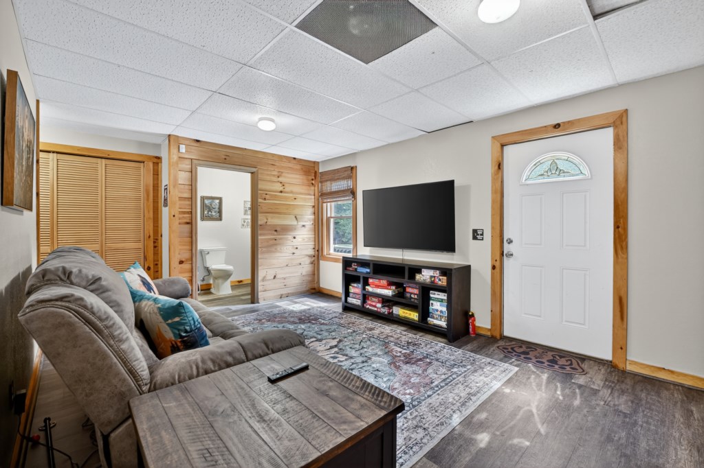 Comfy living area with large TV and a selection of board games, ideal for family fun.