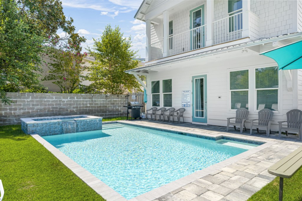 Pool area with a waterfall spa and gas grill