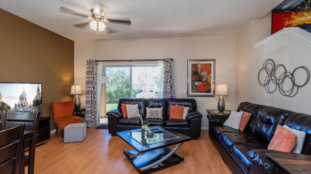 Living Room
Welcoming living space with two leather sofas, vibrant décor, flat-screen TV, and sliding glass door.