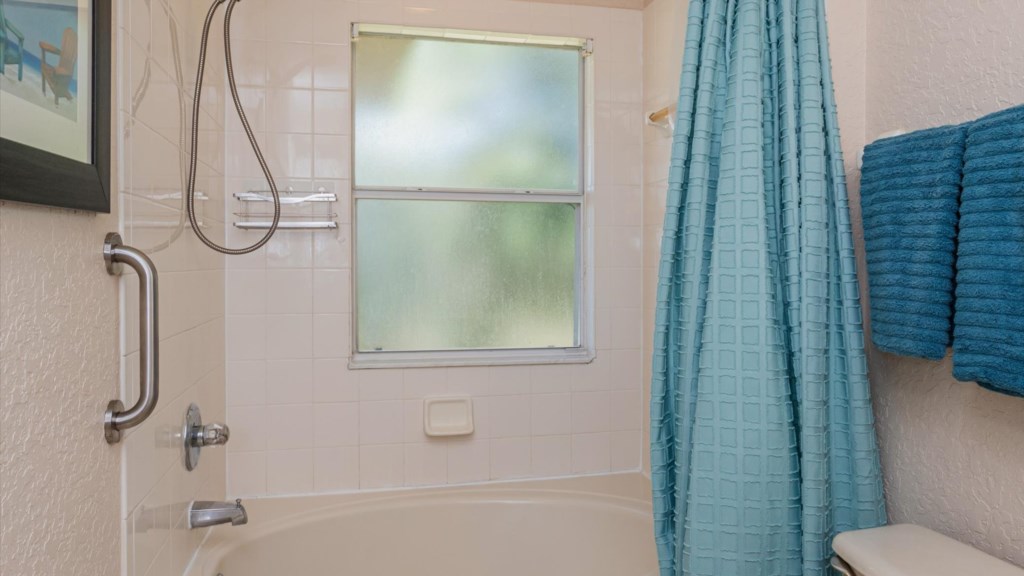 Master Bathroom
Full bathroom with a combination tub/shower, fresh blue towels, and a bright window.