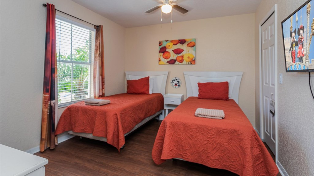 Twin Bedroom
Bright and cozy guest bedroom with two twin beds, vibrant red bedding, and wall-mounted TV.