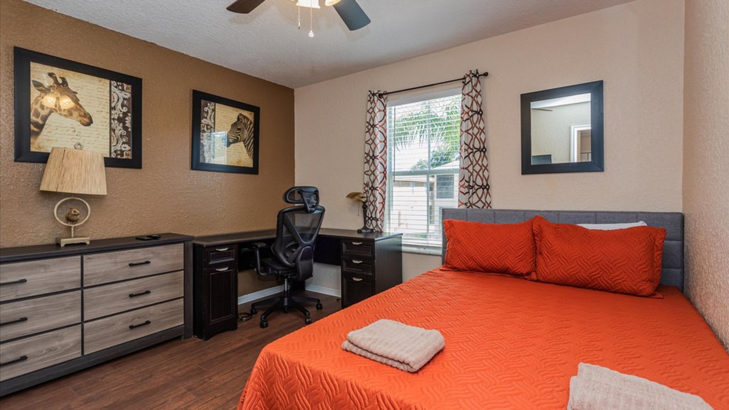 Queen/Office Bedroom
Stylish guest room featuring a queen bed with red bedding, a spacious dresser, desk, and office.