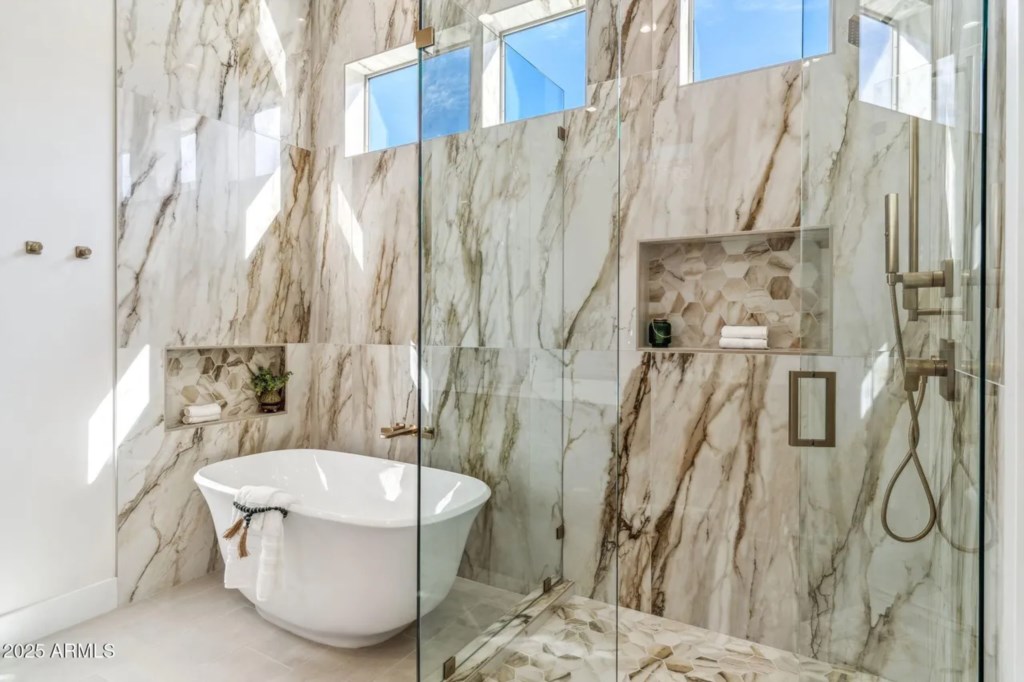 Luxurious marble bathroom with a freestanding tub and glass-enclosed shower for ultimate relaxation.