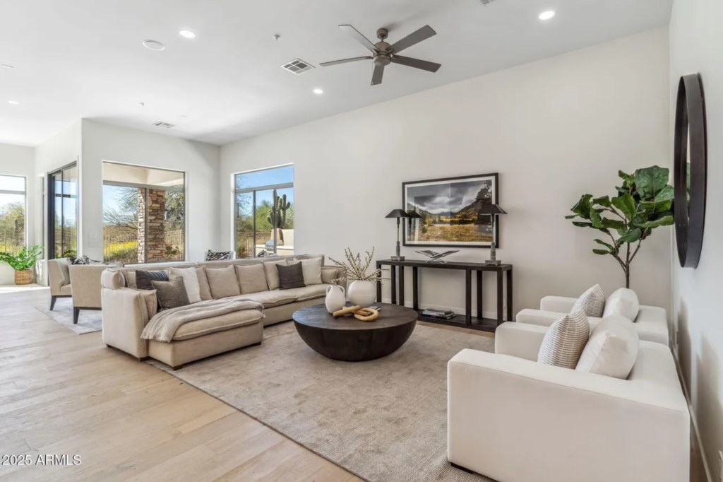 Spacious living room with plush seating and desert views, perfect for relaxation.
