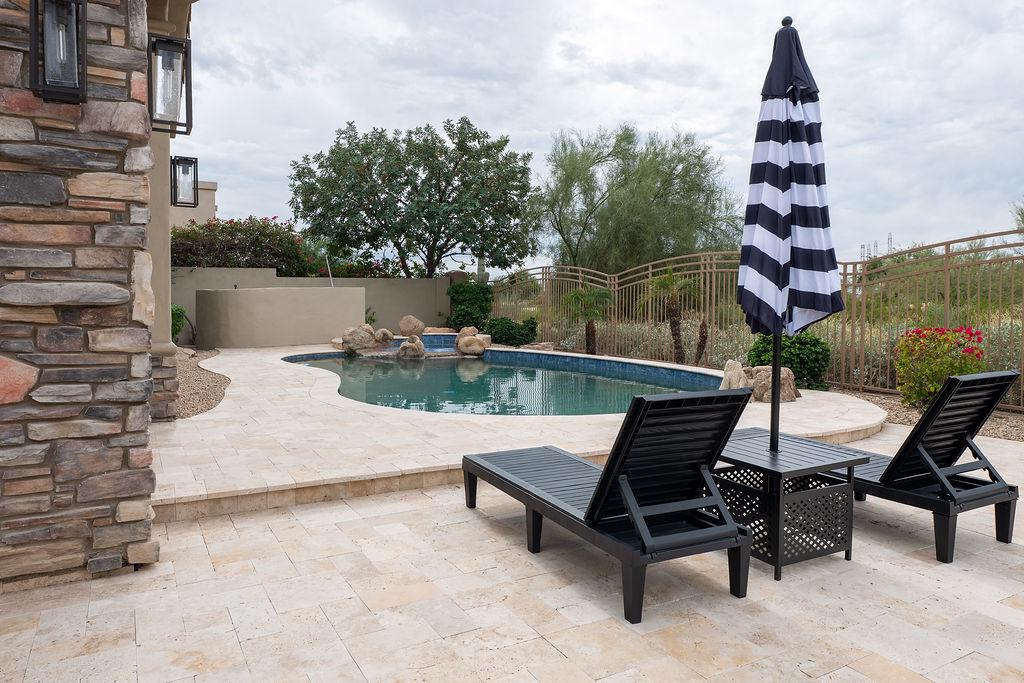 Pool area with pool lounges and umbrella