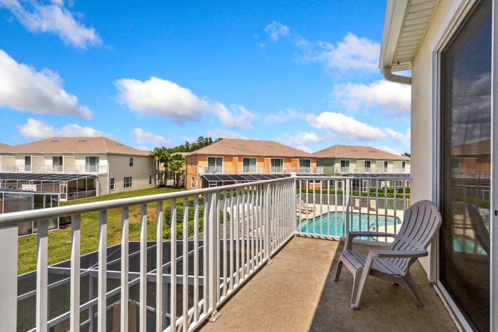 Private balcony with seating, overlooking the community pool.