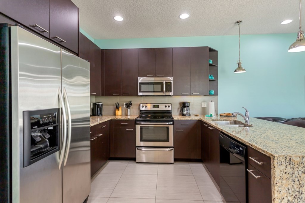 Fully equipped kitchen with modern stainless steel appliances.