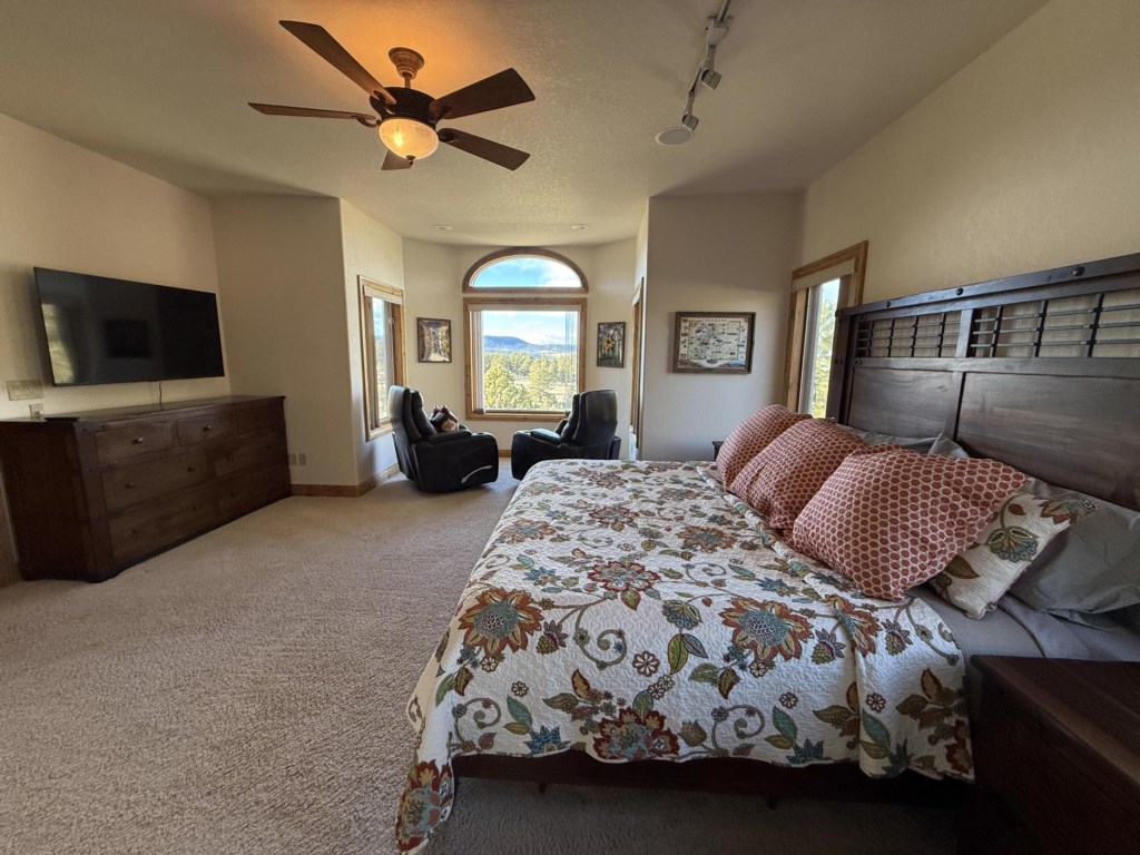 Primary bedroom with King bed, 2 recliners, and large screen tv. Perfect retreat after a fun day of hiking and fishing.