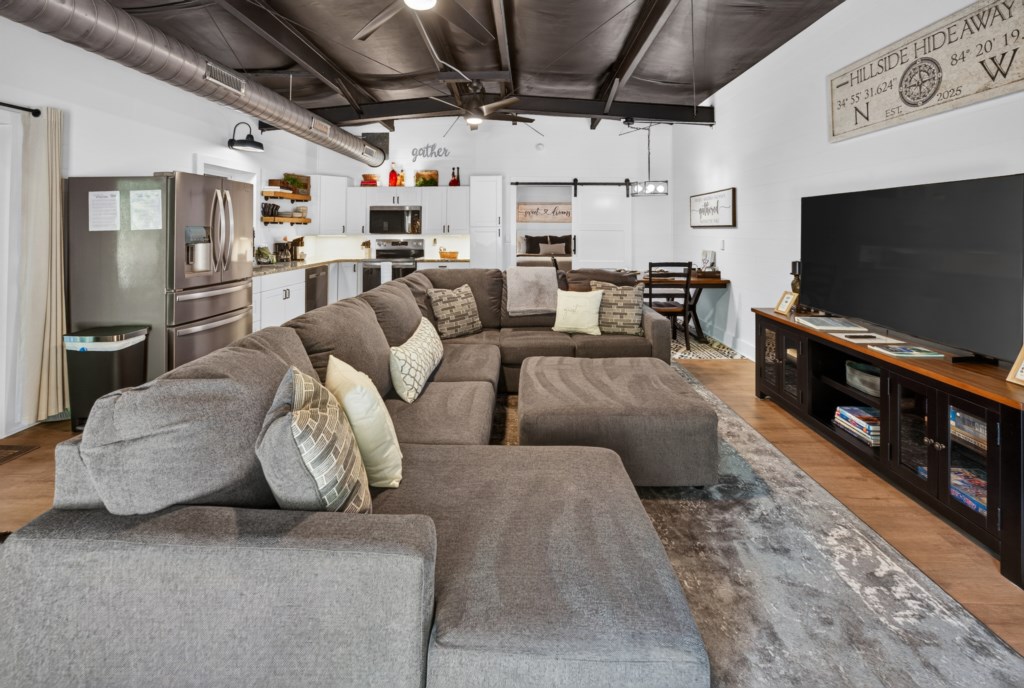 Spacious living area with plush sectional and large TV, perfect for family movie nights.