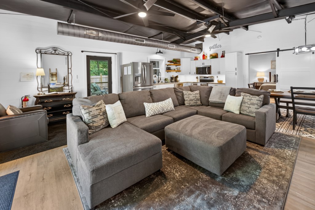 Spacious open-plan living area with cozy sectional and modern kitchen, perfect for family gatherings.