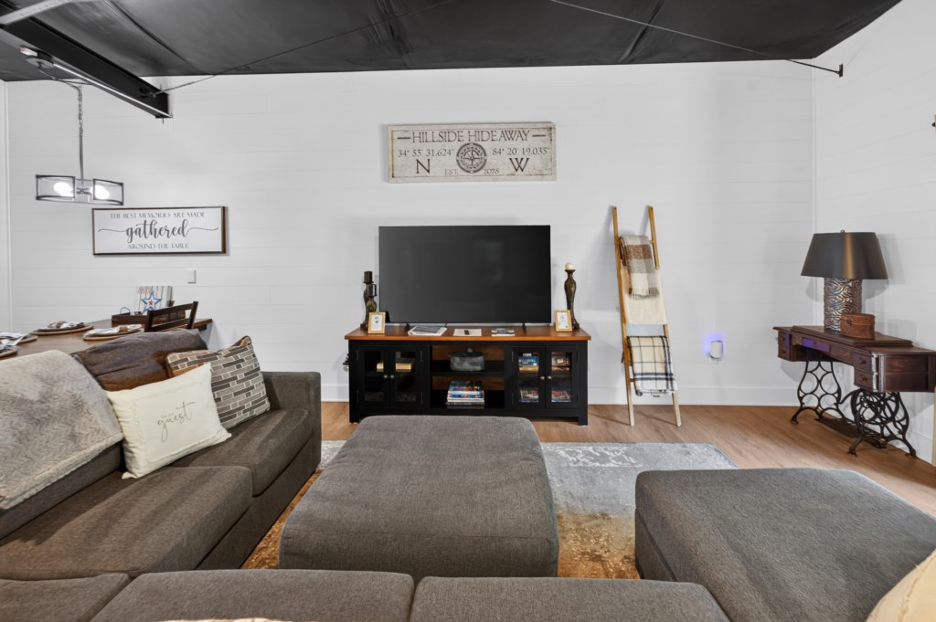 Cozy living room with plush seating and a large TV for relaxing evenings.