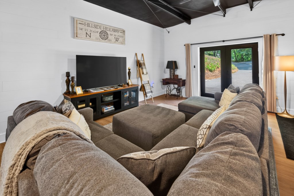 Cozy living room with plush sectional and large TV, perfect for movie nights.