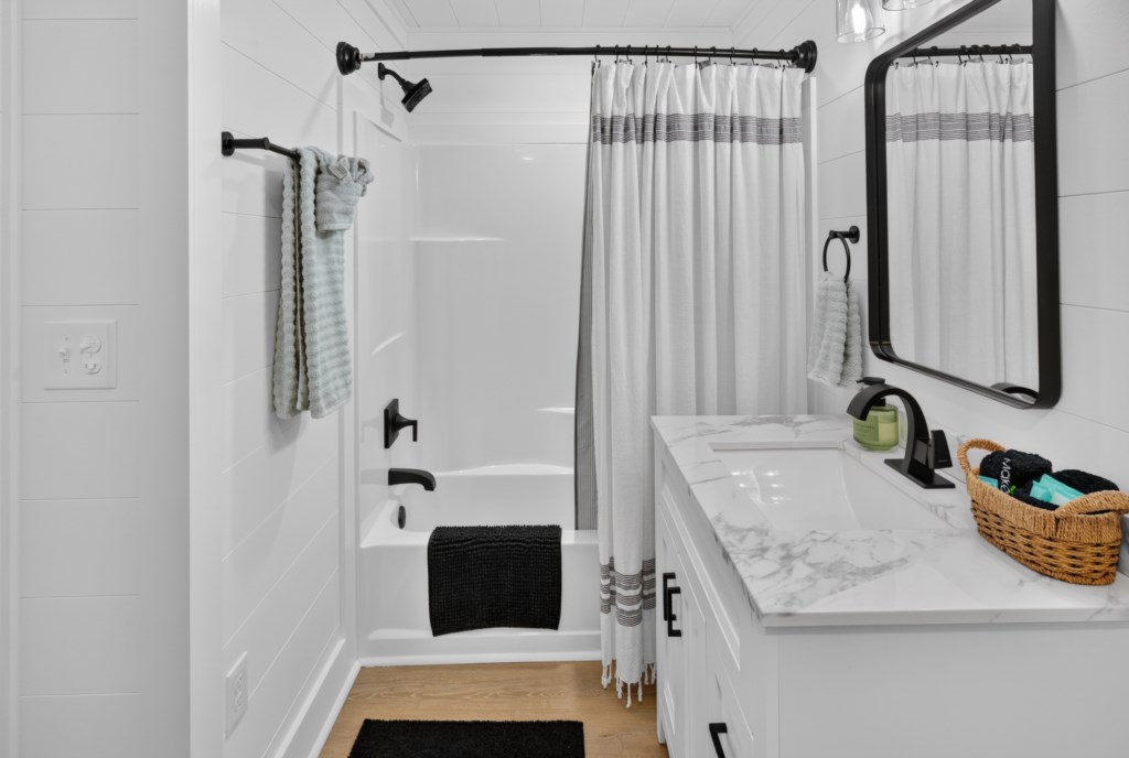 Modern bathroom with marble countertop and stylish black fixtures.