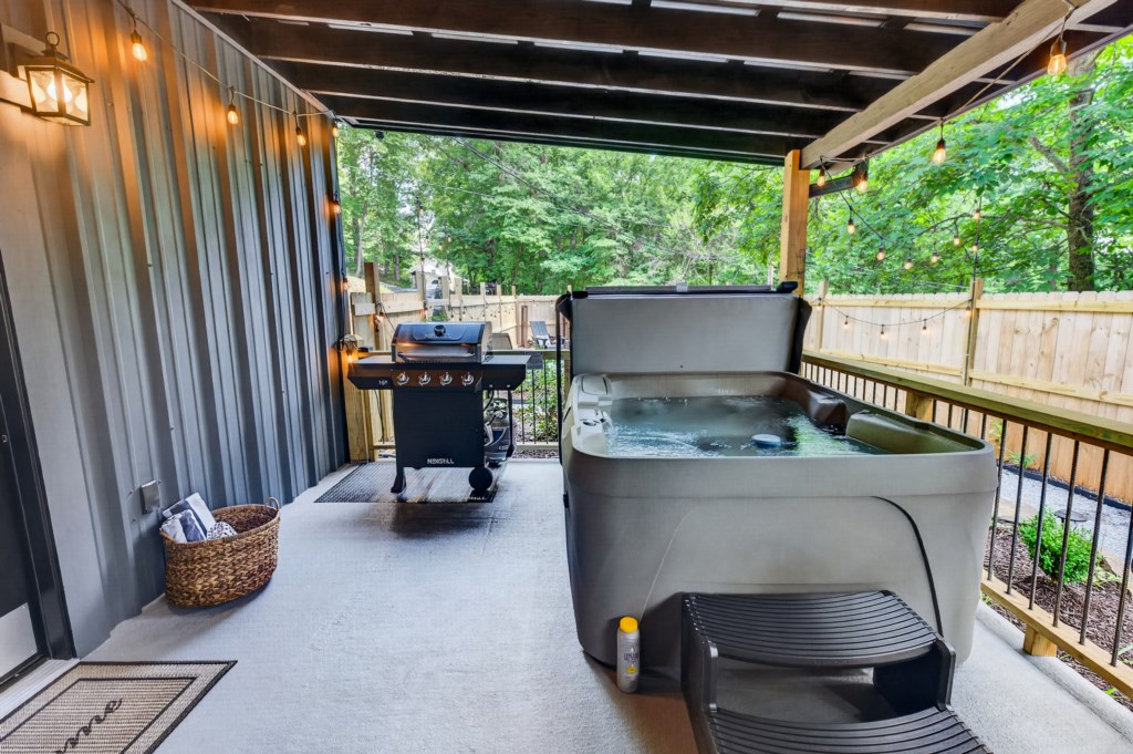 Relax on the covered patio with a hot tub and grill, perfect for outdoor gatherings.