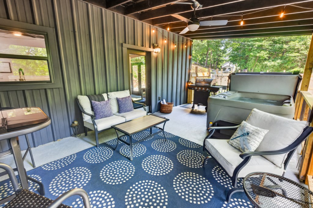 Relax on the covered patio with seating, a hot tub, and outdoor grill.