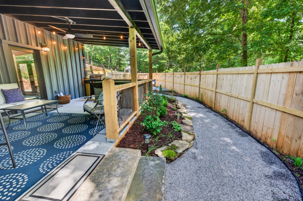 Charming covered patio with seating and grill, perfect for outdoor relaxation.