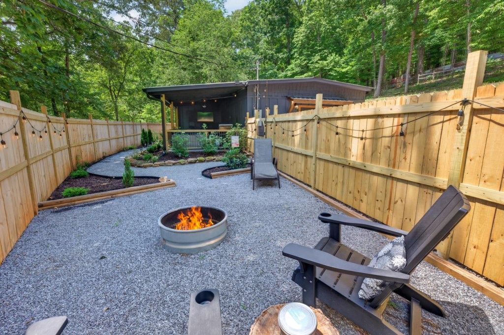 Cozy backyard with firepit and Adirondack chairs, perfect for evening relaxation.