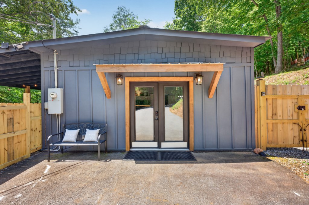 Charming cabin entrance with cozy seating and rustic wood accents.