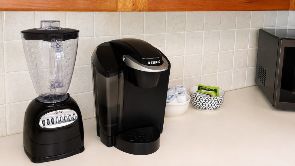 Coffee station with Keurig, blender and complimentary beverage supplies.