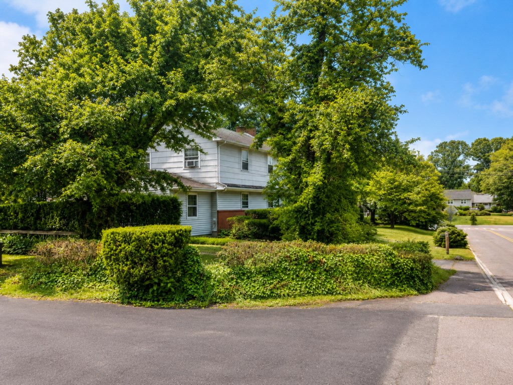 Side view of the home on a quiet residential corner with mature trees.