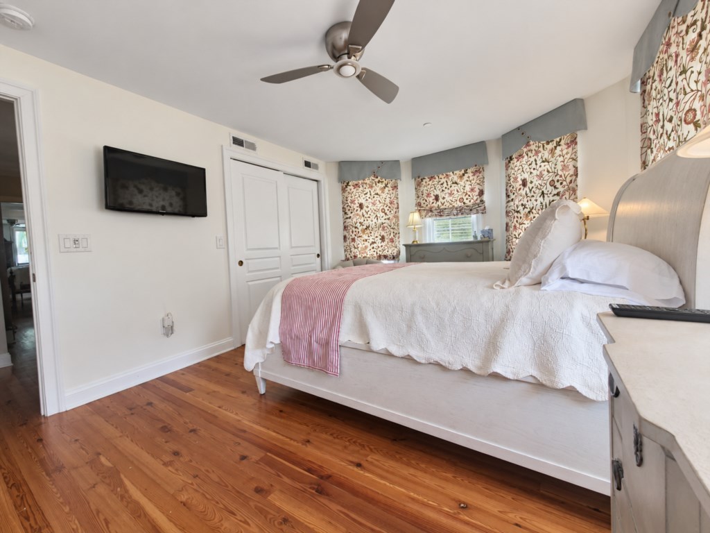 Bright, comfortable queen bedroom with beautiful hardwood floors and plenty of natural light.