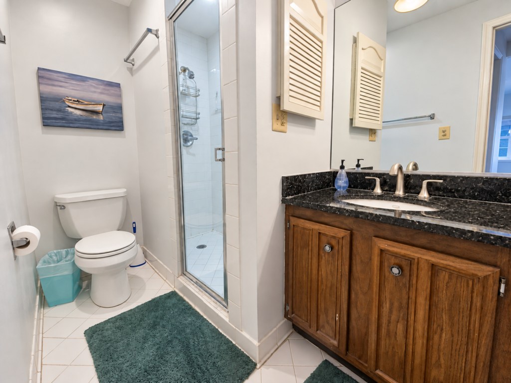 Bathroom vanity with a dark countertop and wood cabinetry.