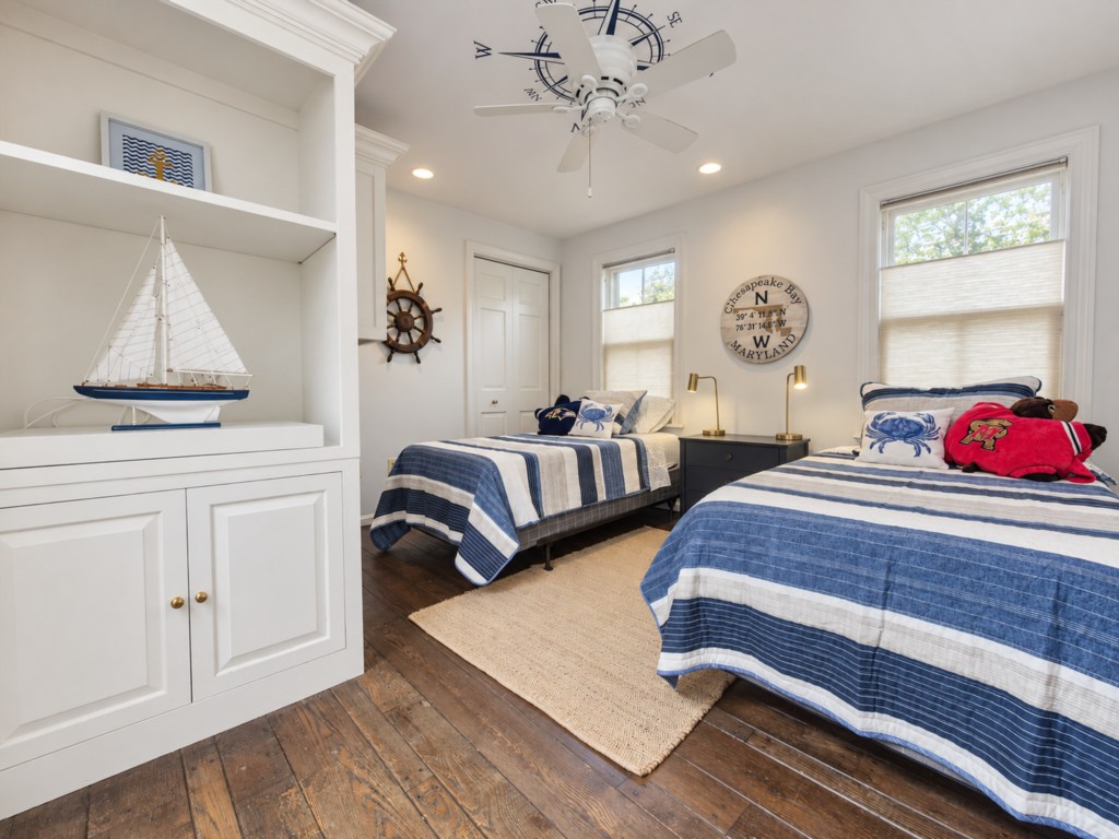 Twin bedroom with nautical accents and built-in shelving.